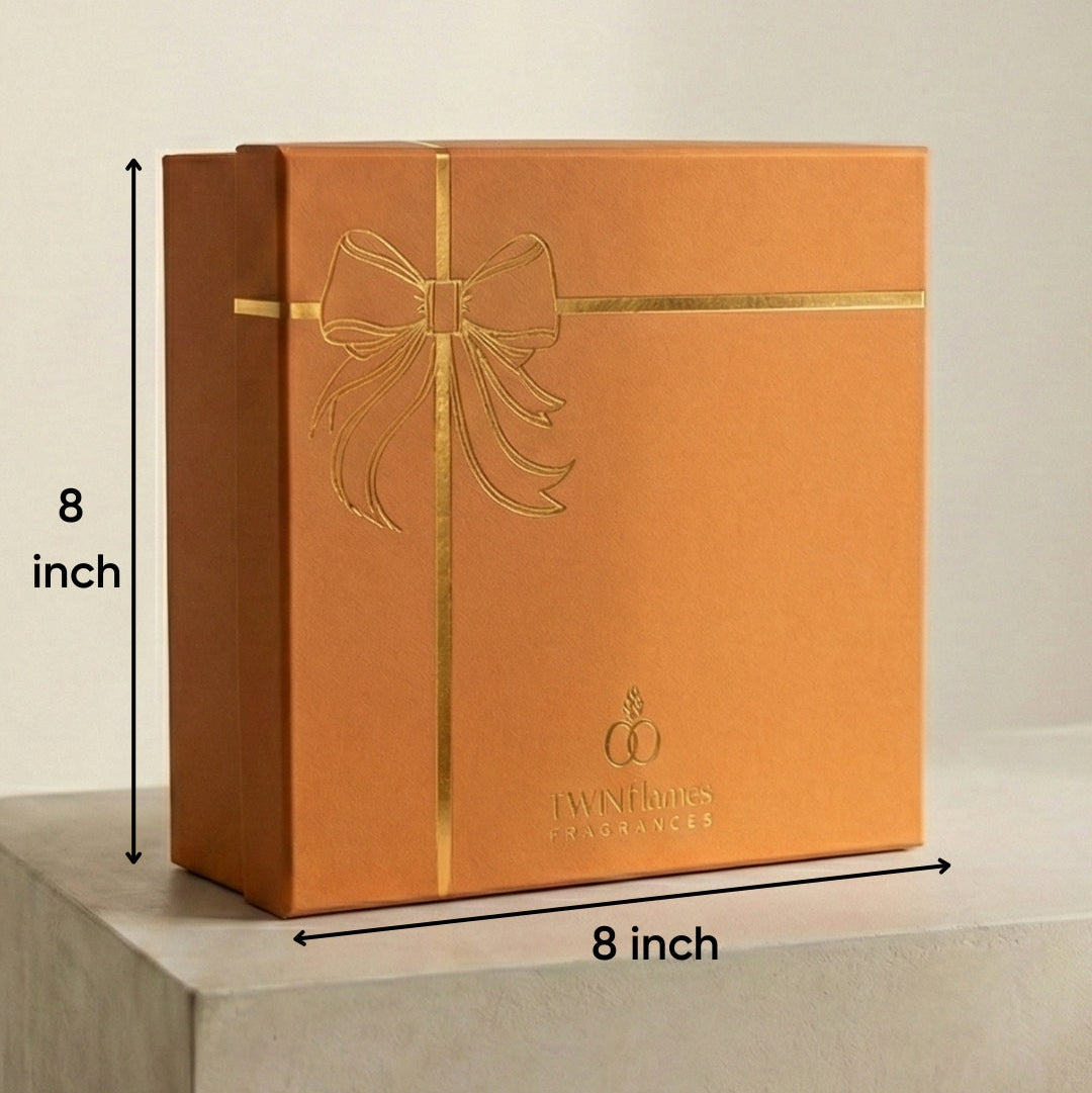 Orange gift box with gold bow design and dimensions on a neutral background